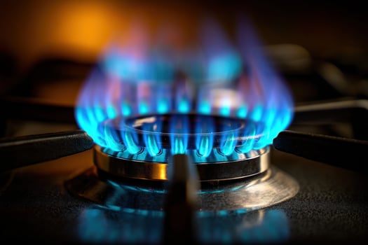 Blue flames rise from a stovetop burner, casting warm light in the kitchen photo