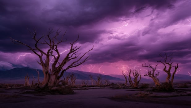 Stormy weather over a barren landscape with dead trees and distant mountains photo