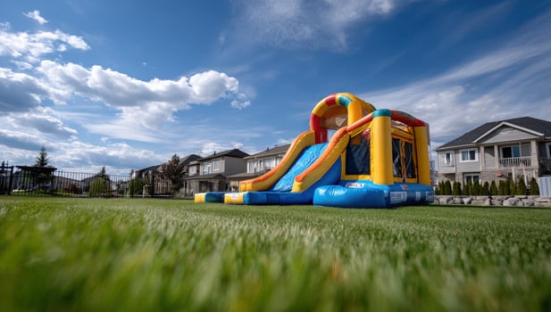Backyard fun. Inflatable bounce house on green grass lawn on summer day photo