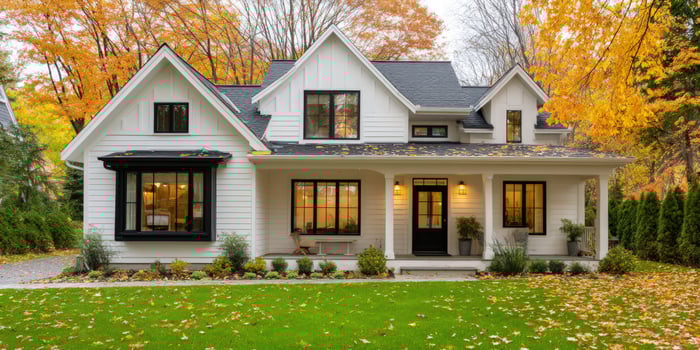 Autumn home White house front with fall foliage. Real estate ad photo