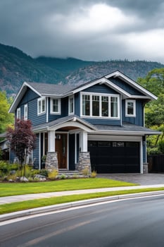 Blue house with dark garage, mountains in background, residential, real estate use photo
