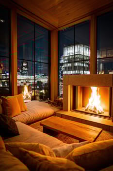 Cozy room with fireplace, looking out on illuminated city at night photo