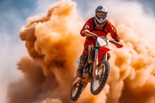 Dirt biker leaps skyward amid clouds of sand at a desert sports event photo
