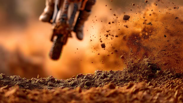 Dirt bike shreds through the ground, off-road track, dirt flying in background photo
