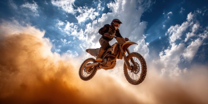 Motocross rider jumping over clouds photo
