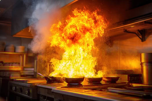 Fiery cooking mishap with a stove engulfed in flames in a commercial kitchen photo