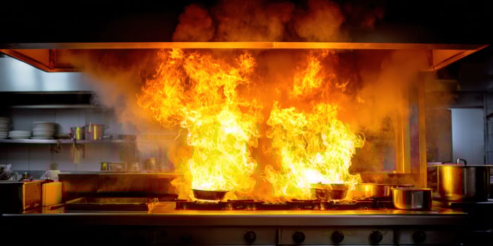Fiery flames erupt from pots on a kitchen stovetop, smoke filling the air photo