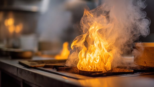 Flames ignite on a stove top in a bustling kitchen, surrounded by steam and pots photo