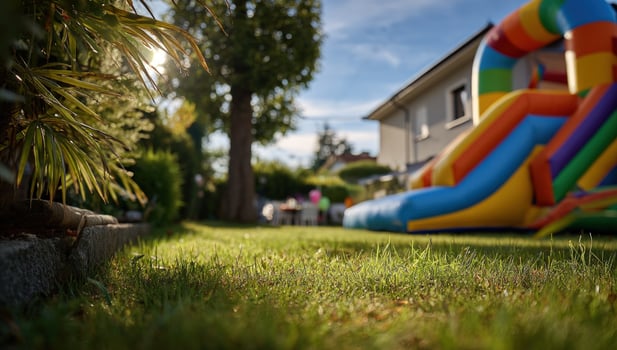 Inflatable slide in yard ready for kids party with lawn, family in backyard photo