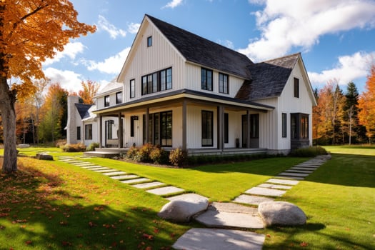 Large home in autumn, surrounded by vibrant foliage, walkway, and blue sky photo
