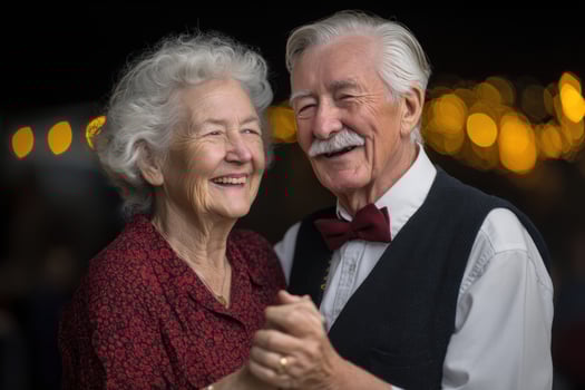 Smiling elderly couple dancing, celebrating together, with warm, glowing bokeh lights photo