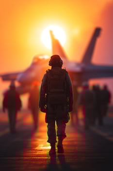 Soldier strides towards plane on airstrip in sunset with colleagues in background photo