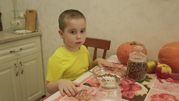 A small child happily eating a nutritious breakfast while sitting in a cozy kitchen setting photo