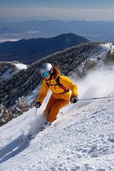 Woman skiing down snowy mountain slope on a sunny day with blue sky backdrop photo