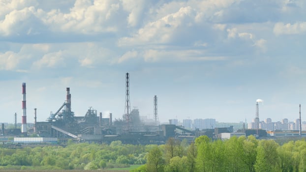 Industrial Landscape Featuring Prominent Smokestacks and a Dramatic Cloudy Sky Above photo