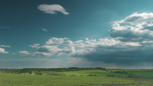 A Serene Green Landscape Beautifully Enhanced Under Dramatic Clouds in the Sky Above Time lapse. photo