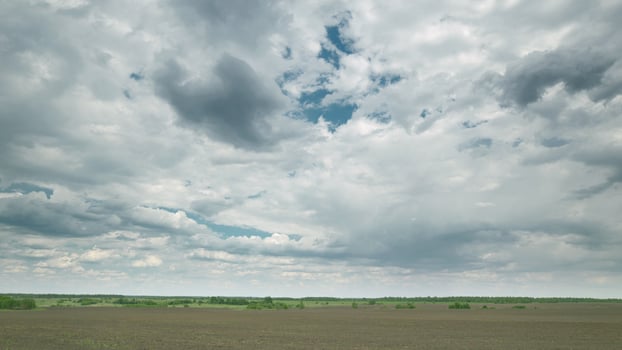 An Expansive Cloudy Sky Spreads Over the Vast Farmland Beneath It, Creating a Beautiful Scene Time lapse. photo