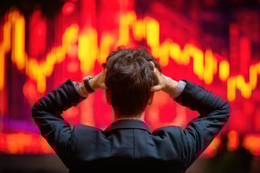 Anxious man watching market crash, holding his head with red stock chart back photo