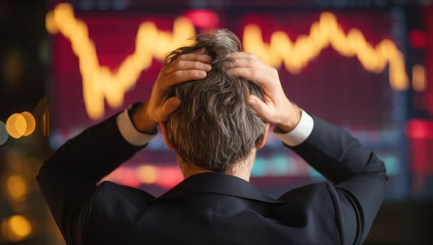 Stressed man looking at stock market graph downfall with blurred cityscape photo