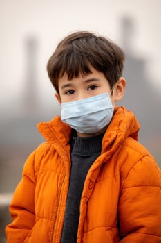 Child wears a mask outside in a polluted city with distant industrial chimneys photo