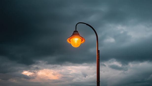 Lit streetlight illuminating dark clouds in the sky, conceptual, background image photo