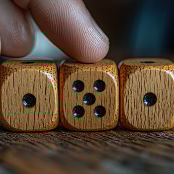 Closeup of Wood Dice Showing One, Five, and One with a Finger on Top, Gambling Concept photo