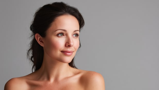 Attractive woman looking away at empty space for advertising on a grey backdrop photo