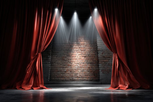 Dramatic red stage curtains open to a brick wall lit by bright spotlights photo