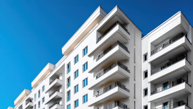 Modern white apartment building, balcony views, clear blue sky background photo