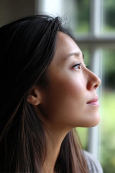 Woman looks through window in house, hopeful and peaceful in background photo