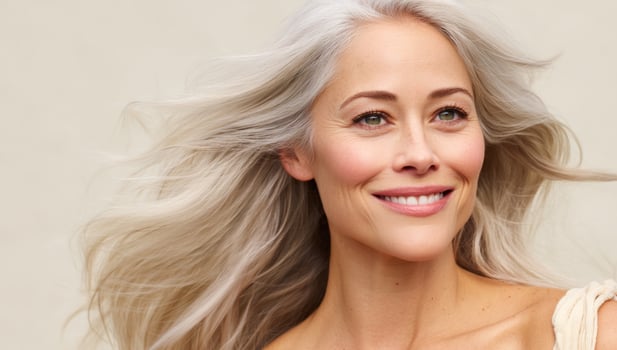 Smiling senior woman with gray hair looking up against neutral background photo