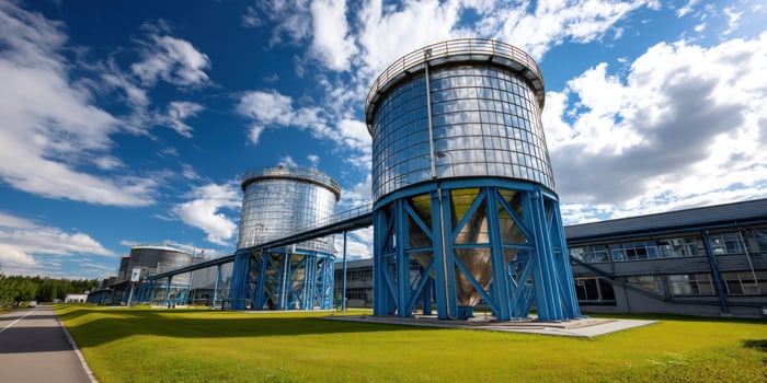 Tanks storing liquids at an industrial site with lush green and blue skies photo