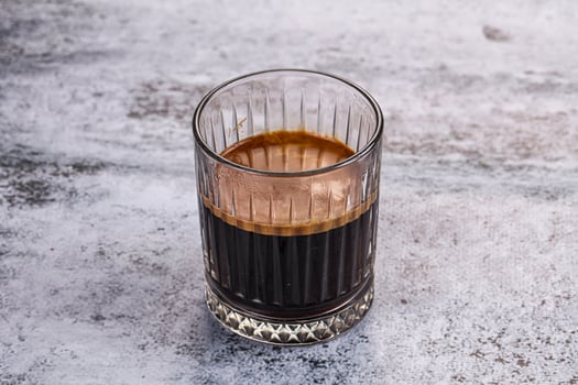 A glass of coffee with a dark liquid in it photo