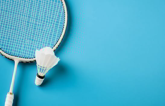 Badminton racket and shuttlecock on a vibrant blue background photo