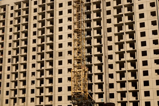 A construction site showcasing a crane alongside a newly developing building facade photo