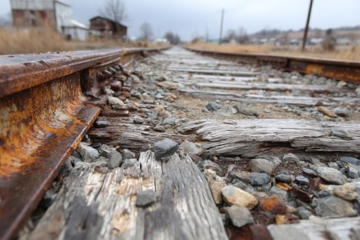 A rusty railroad track with a few rocks and gravel photo