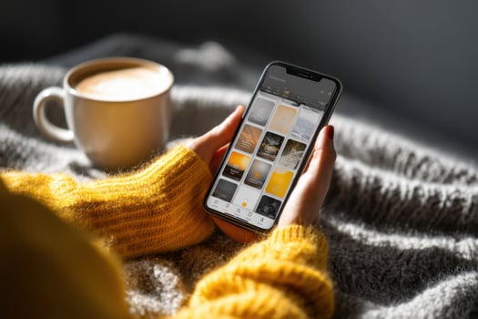 A woman's hand holding a smartphone with a photo app on it
