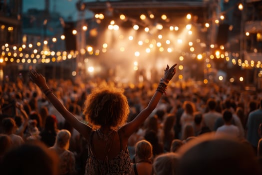 A woman with her arms up at a concert photo