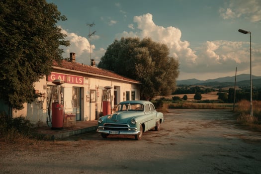 An old car parked in front of a gas station photo