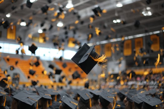 Graduates toss their caps into the air photo