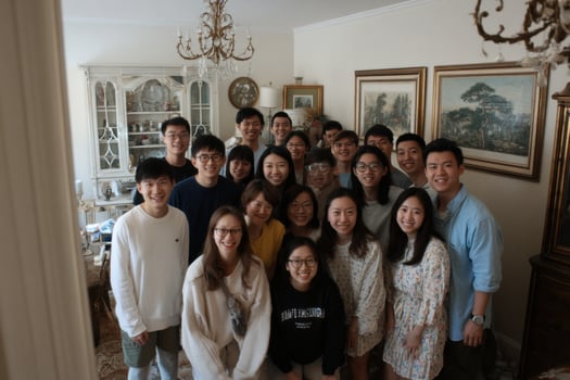 A group of young people posing for a photo in a living room