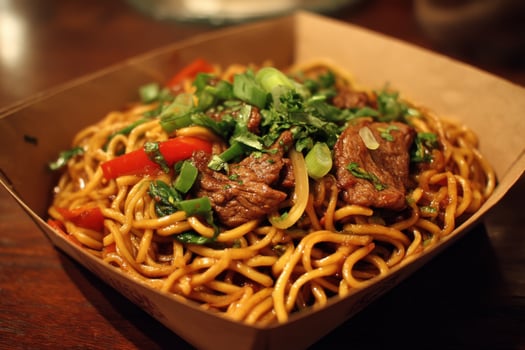 A box of noodles with meat and vegetables in it photo