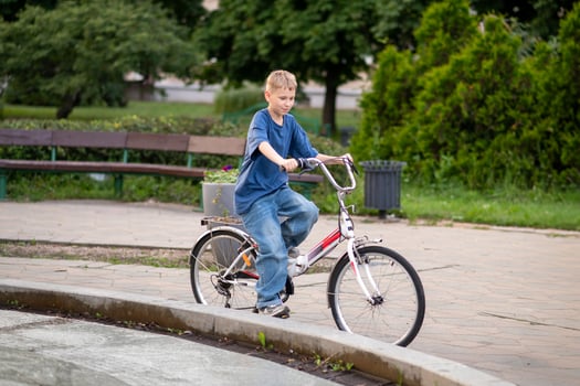 boy riding bicycle in urban park on a sunny day photo