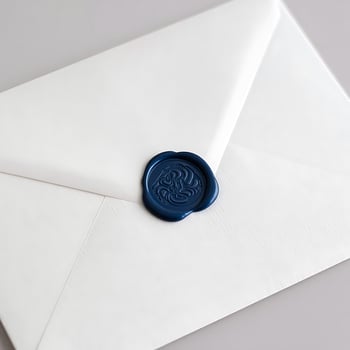 Elegant White Envelope Sealed with a Dark Blue Wax Seal for Invitations and Special Occasions photo
