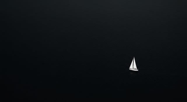 A sailboat floating in the dark ocean photo