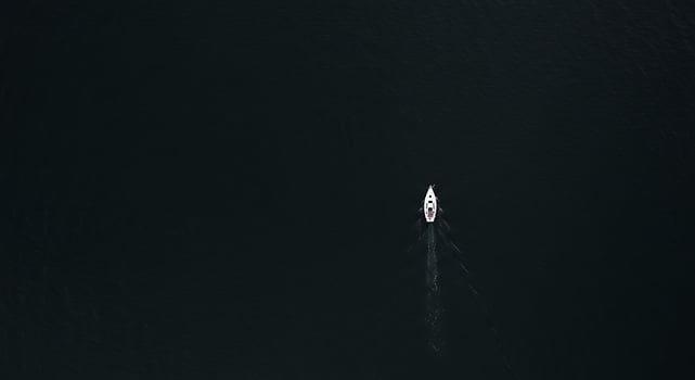 A boat is sailing in the dark water photo
