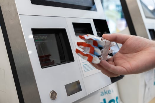 Consumer scans multiple packaged chocolate snack bars at a modern self-service kiosk, emphasizing automated retail processes and quick purchasing convenience photo