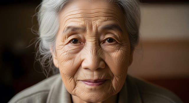 A close-up of an elderly woman with silver hair and deep-set eyes. photo