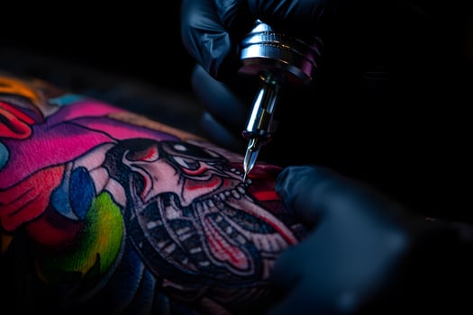 Tattoo artist inking detailed colorful snake design on client's arm, close-up of tattoo machine in action photo