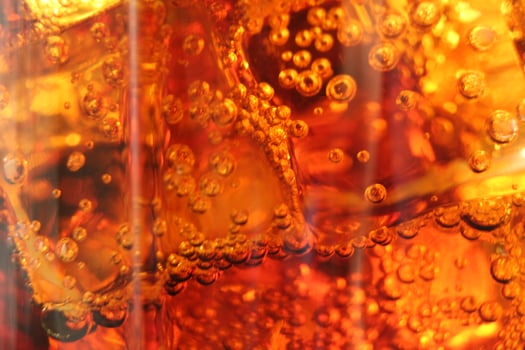 macro drink kvass Cola with ice close-up bubbles in drink soda on a dark black background photo